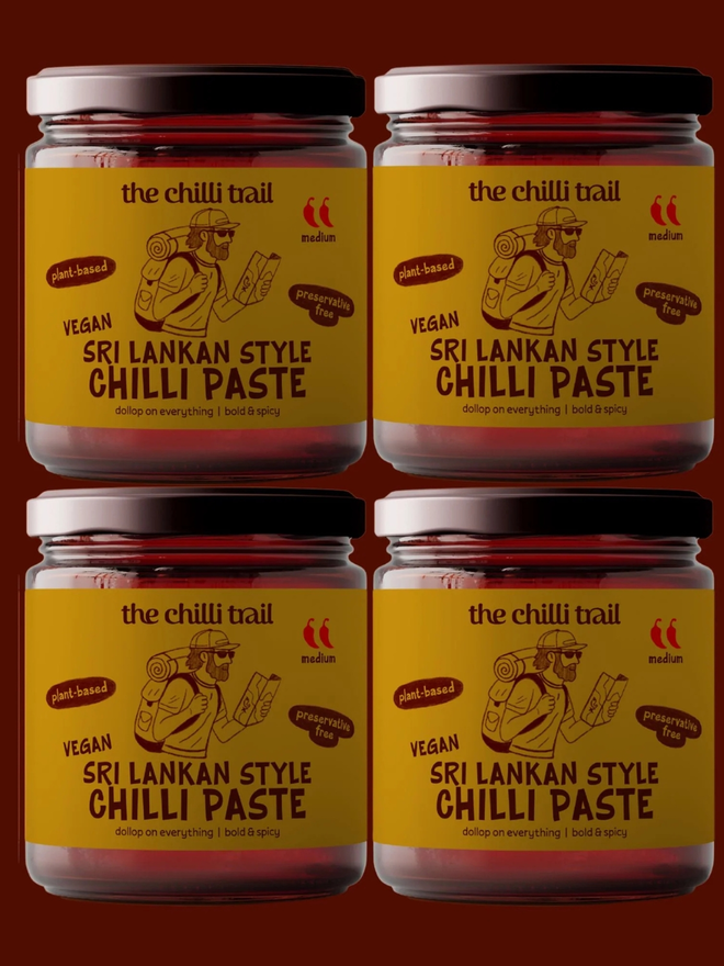 'the vegan 4' chilli paste bundle. four jars of chilli paste photographed against a dark red background.