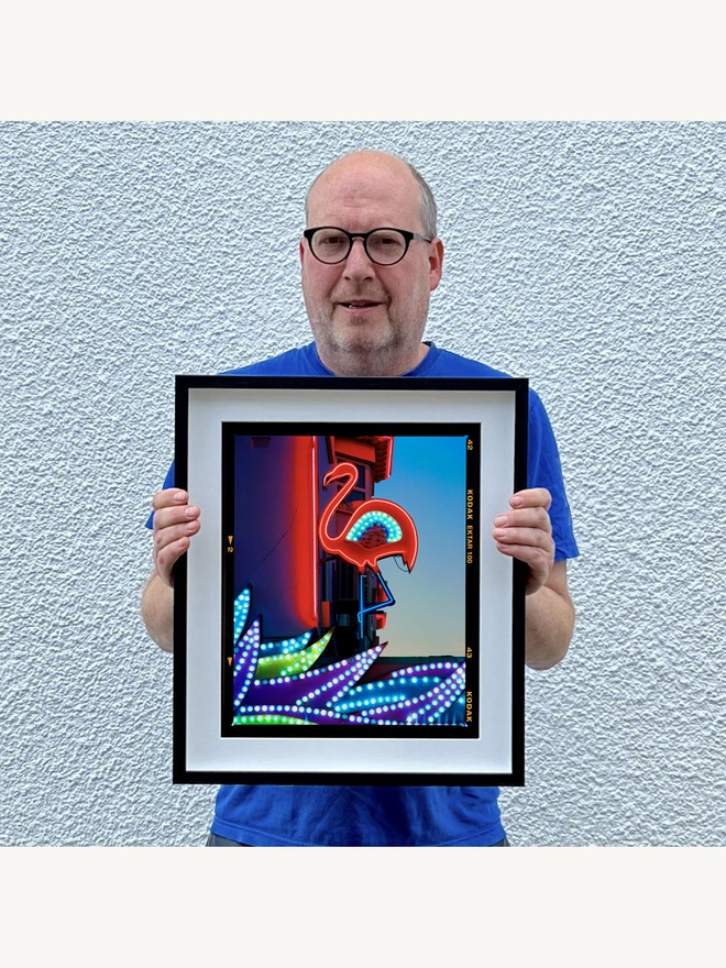 Neon Flamingo Richard Heeps holding colour print framed in black