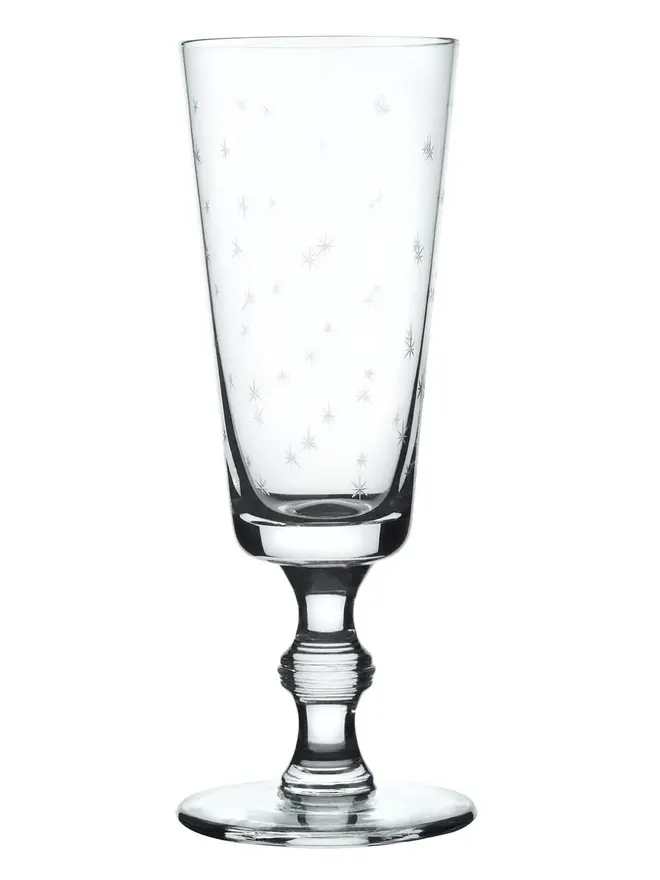 engraved stars champagne flutes (set of 4). a champagne glass patterned with small stars.