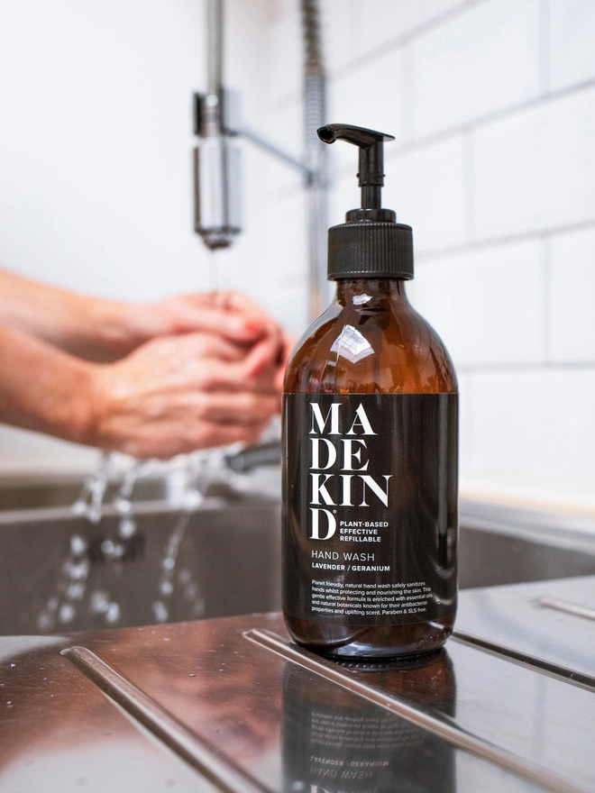 Natural hand wash on kitchen sink with hands washing 