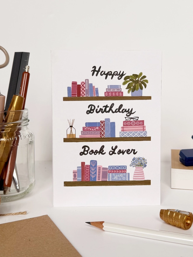 Happy Birthday Book Lover propped up on a desk
