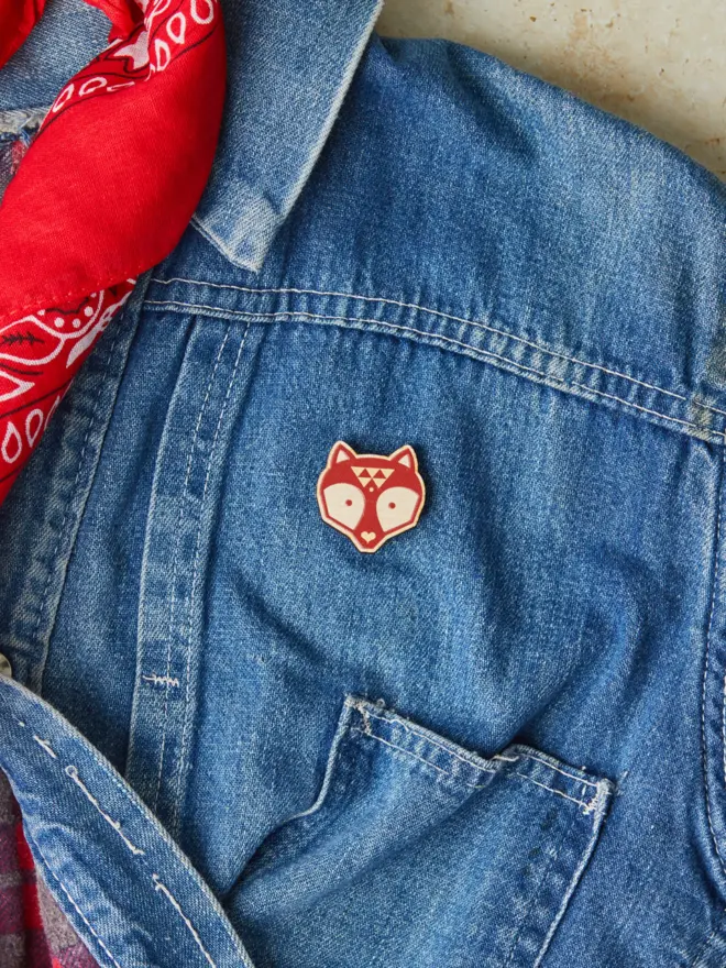 Wooden fox pin badge on a denim jacket