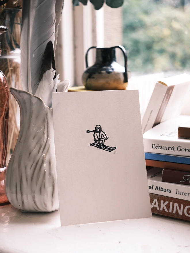 a tiny linocut print of a skiier