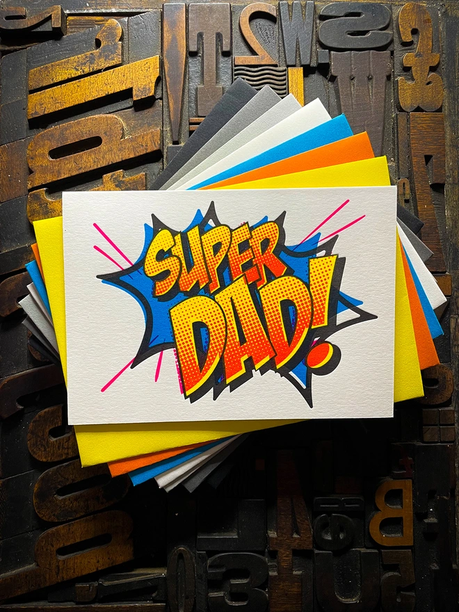 Pop Art Fathers day typographic letterpress card with fluorescent ink made by hand. Deep impression print. Unique with no print being the same. Vibrant colours with matching premium envelopes. With luxurious contrasting coloured envelopes.