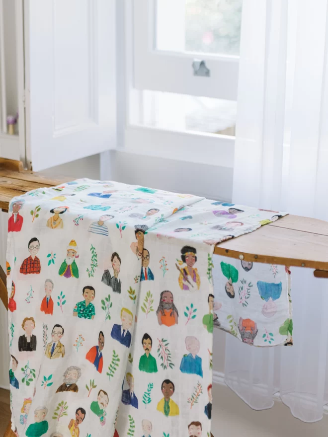 The brightly patterned "exemplary men swaddle blanket" draped over an ironing board. 