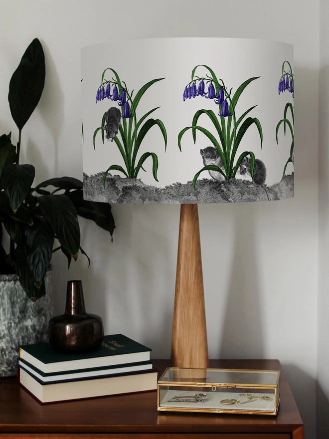 A whimsical lampshade featuring adorable mice hiding among bluebells, creating a charming woodland-inspired design.
