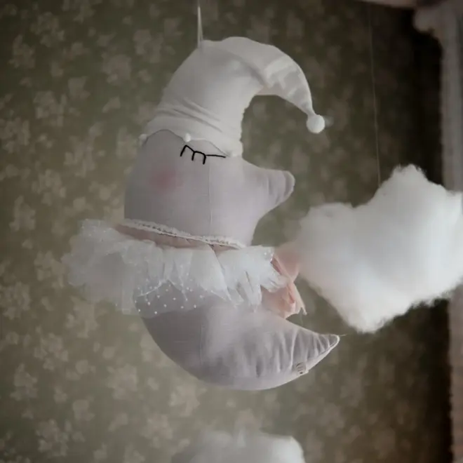 Sleepy Moon Nursery Pillow Hanging Decoration, a hanging pillow decoration suspended in a bedroom. 