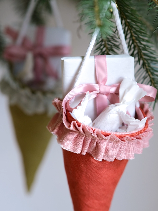 Reusable Victorian Christmas gift cones for hanging beneath festive greenery, featuring delicate ruffled trim.