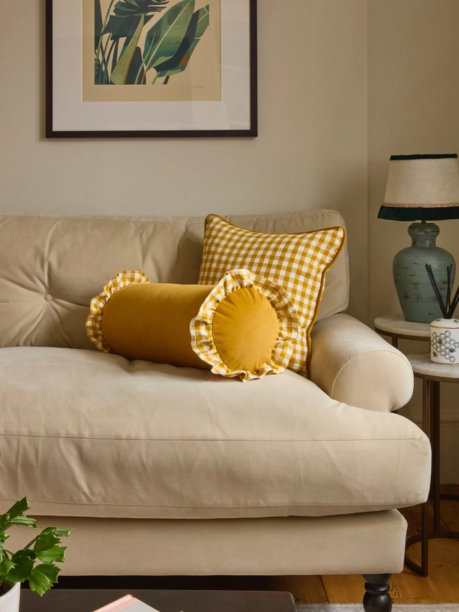 Handmade mustard velvet bolster with gingham ruffle and matching gingham piped cushion on cream sofa, Kika Bespoke