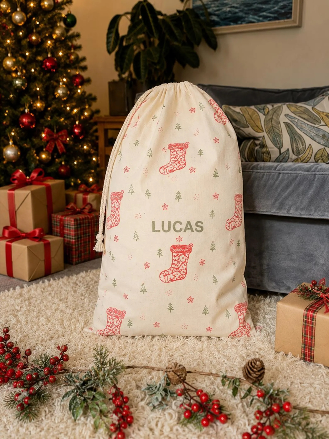personalised drawstring christmas sack. a drawstring bag with printed christmas motifs and a personalised name.