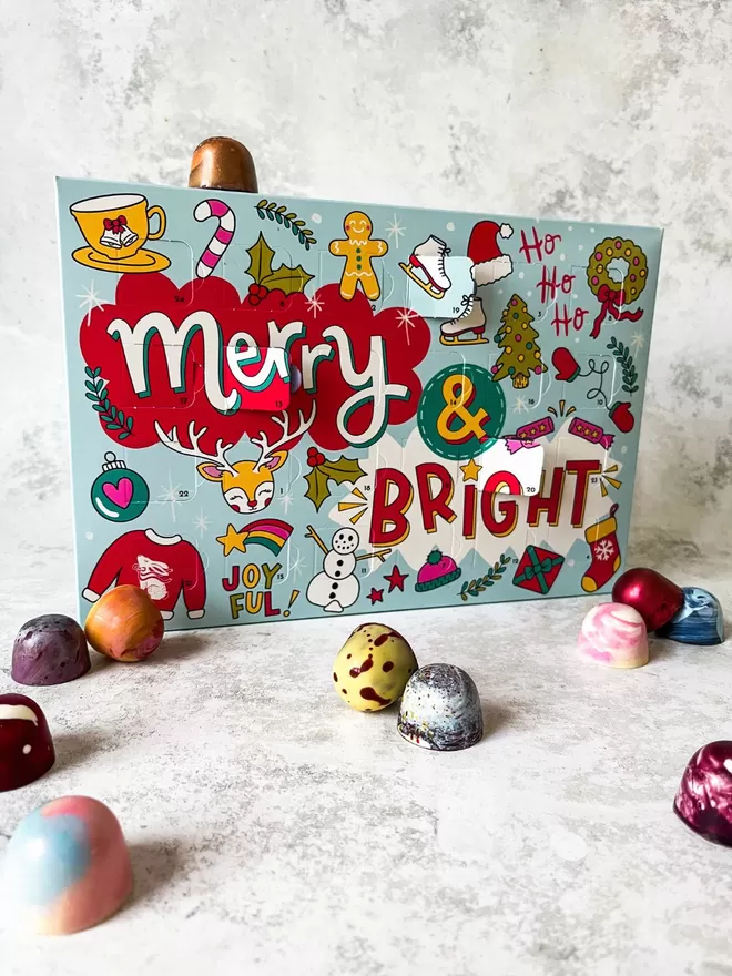 an advent calendar box of chocolates with the words merry and bright written on it with cute christmas illustrations