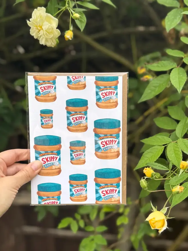 peanut butter jars illustrated card. card photographed against rose bush background.