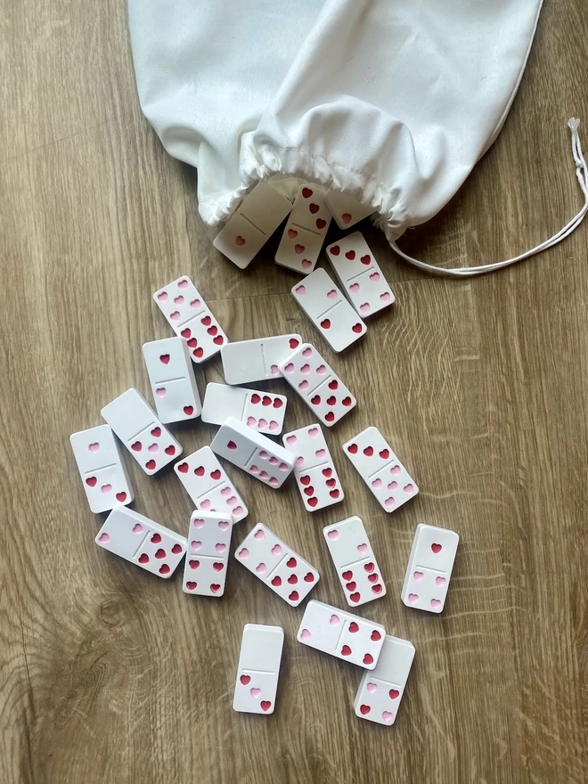 Handmade Valentines And Colourful Jesmonite Dominoes, a group of colourful dominoes on a wooden surface. These have hearts on them. 
