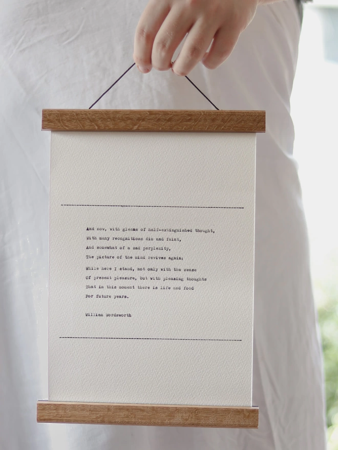 Hand typed wall hanging in a wooden print hanger