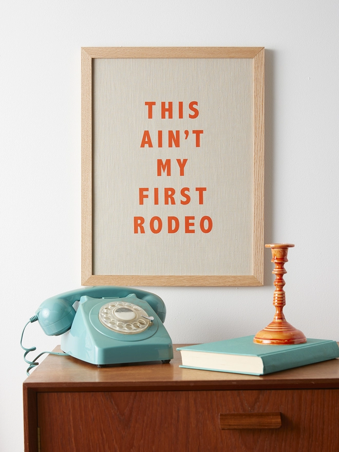 This ain't my first rodeo natural linen picture with orange writing
