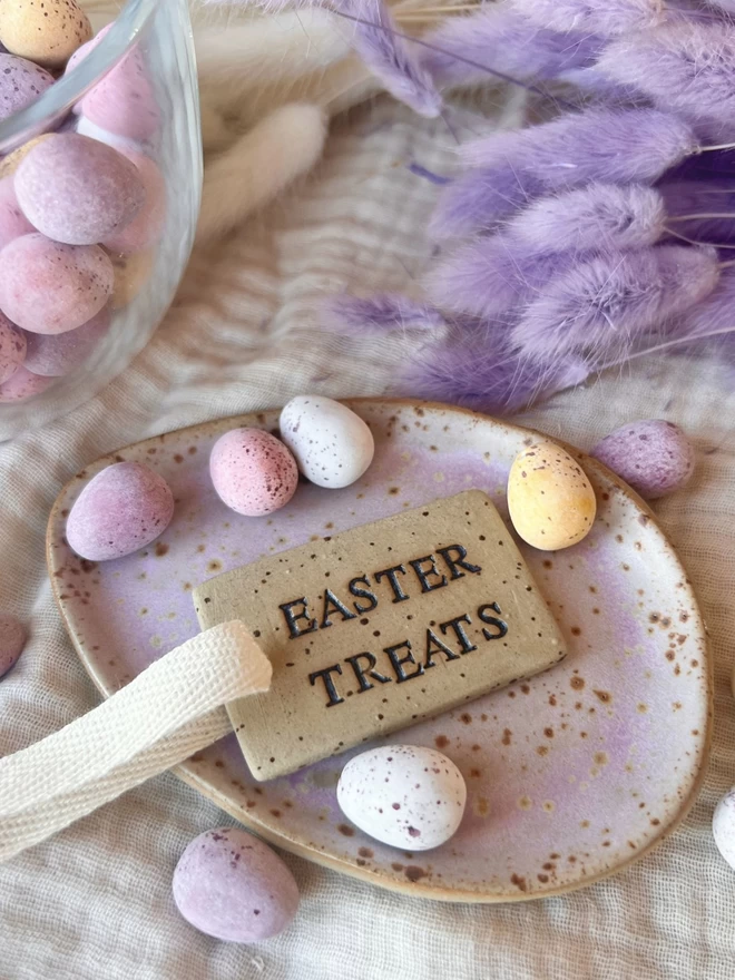 easter treats tag laid on a purple ceramic egg plate