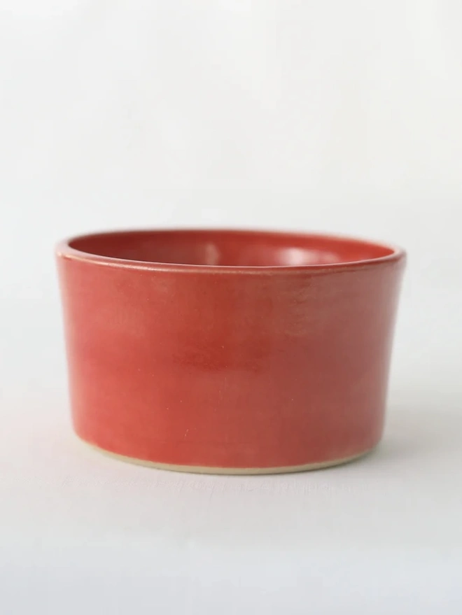 Classic Side Bowl, a colourful ceramic bowl on a wooden surface against a grey backdrop. 