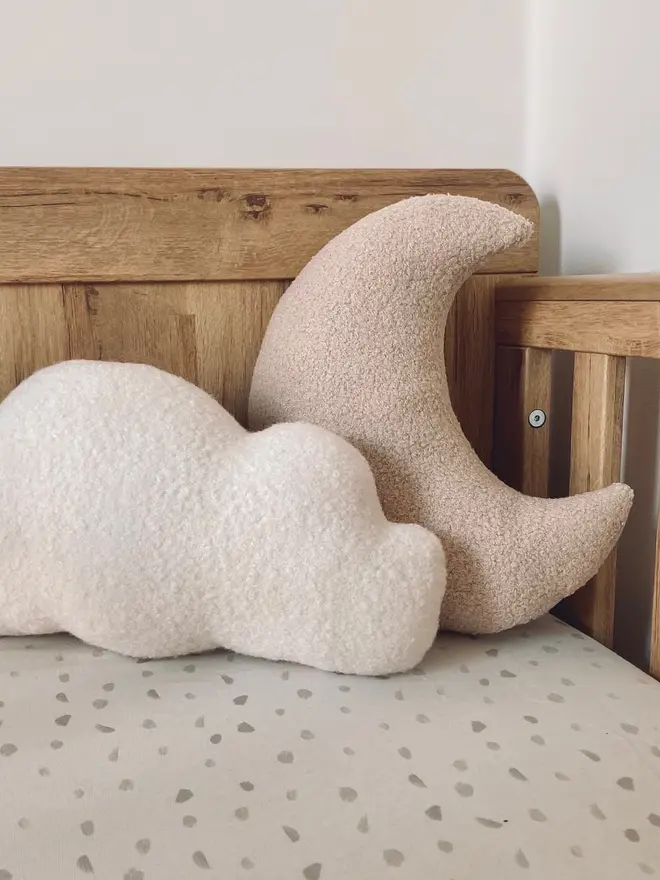 boucle moon and cloud pillow set. a beige moon and white cloud cushion on a sofa.