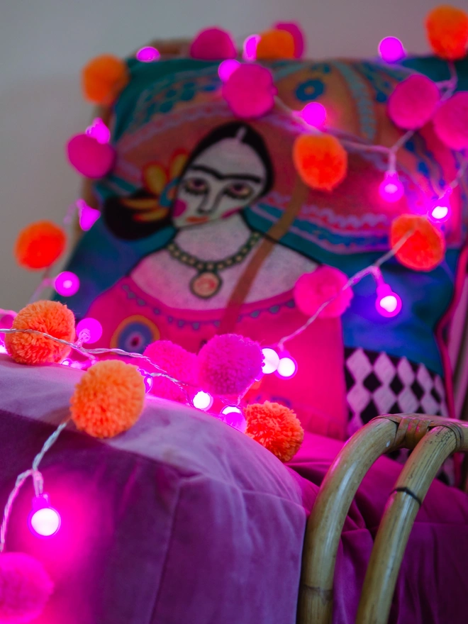 pink and prange pom pom festival light chain with pink LED lights 