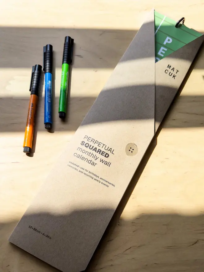 Perpetual Squared: Birthday, Anniversary, Memory Tracker packaging sleeve, next to coloured pens on table