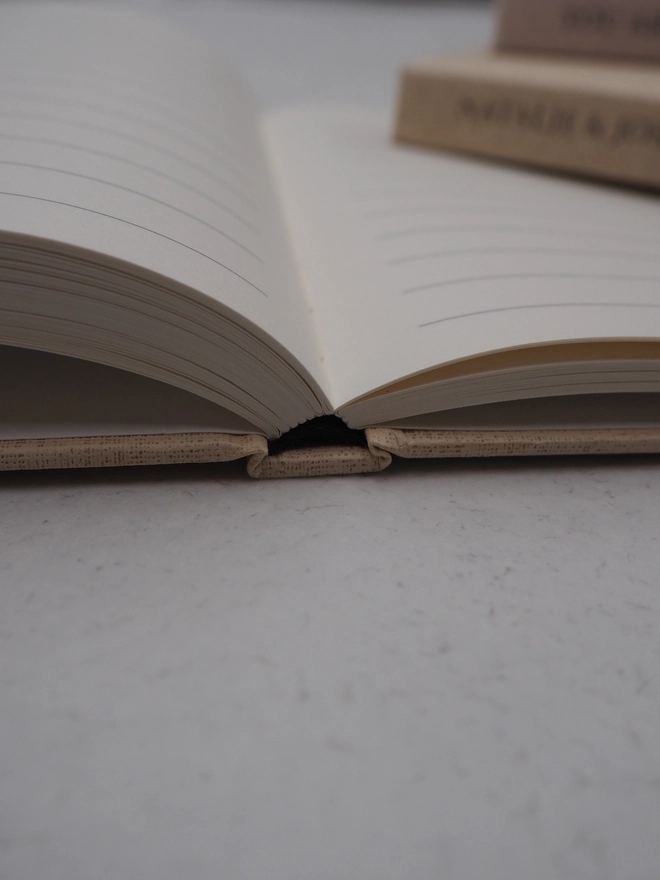 Personalised Baby Shower Guestbook. A close up of a the hardcover book showing the books layflat ability and section sewn pages