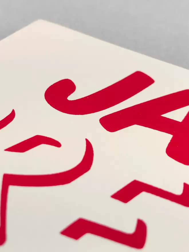 close up of red ink printed on cream card, the JA of Jam is in sharp focus.