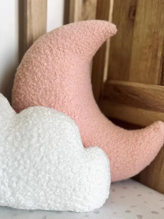 boucle moon and cloud pillow set. a pink moon and white cloud cushion on a sofa.