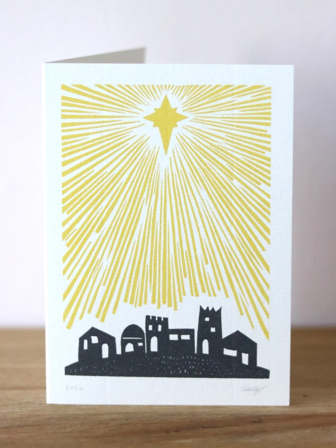 A Christmas card based on an original linocut design featuring Bethlehem and a star