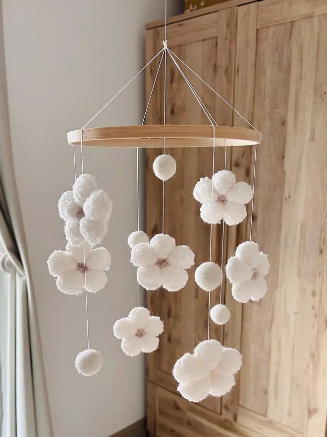 boucle flower baby mobile. a white cloth baby mobile hanging from the ceiling.