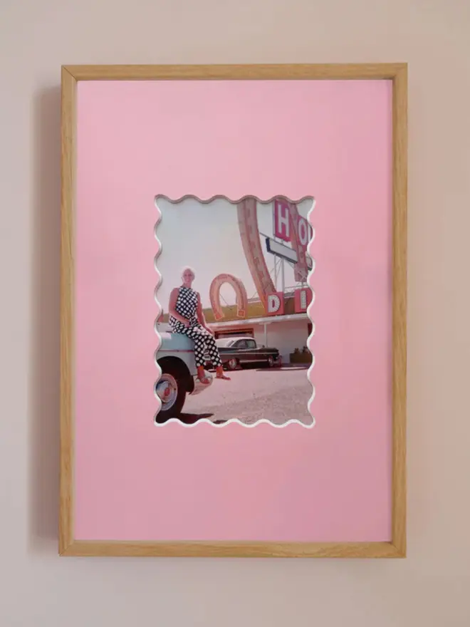 Ric rac photo mount frame with a pink mount featuring a decorative ric rac boarder around a centered Instax photo, displayed on a neutral beige wall.