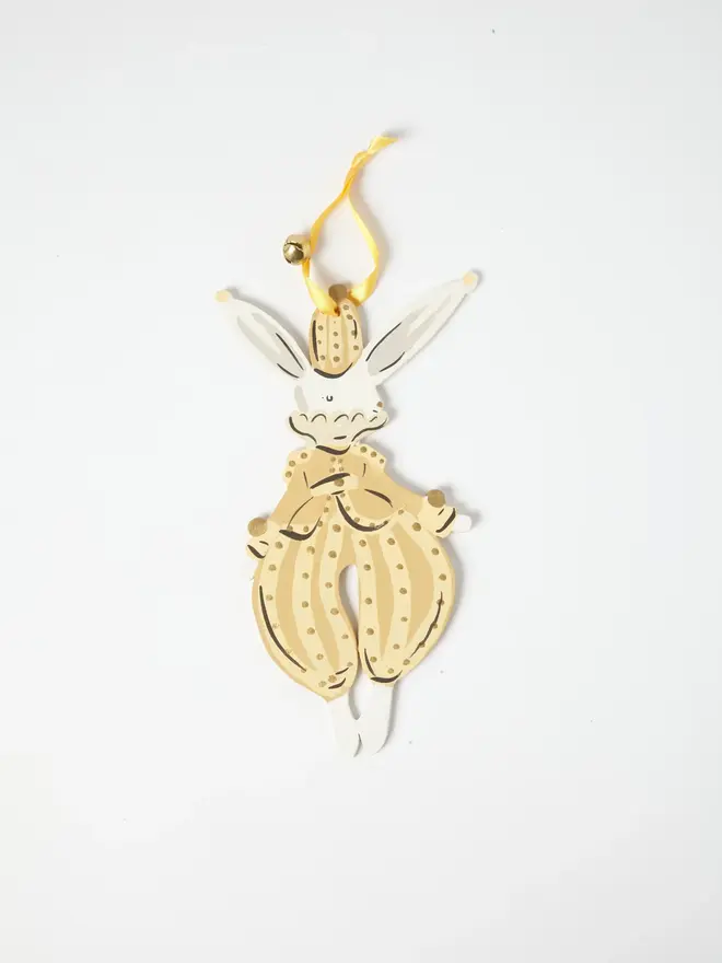 Hare Tree Dancer. wooden hanging hare decoration with a gold top hat, cream polka dot pantaloons with a bow, yellow ribbon with a jingle bell, on a white background