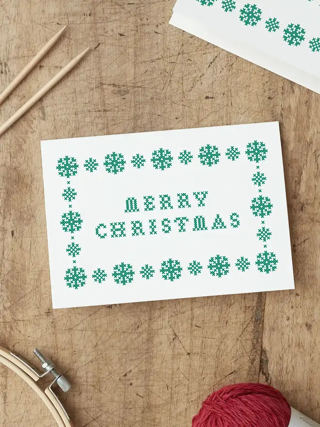 christmas card screen printed with a green cross stitch design