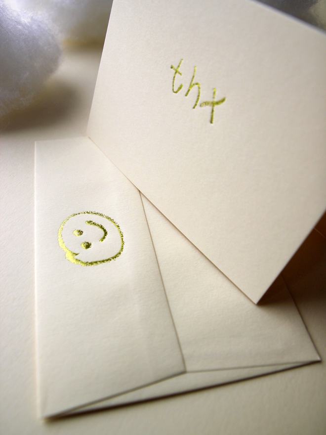 sandy coloured card with thx short for 'thank you' hand foiled in kids hand writing