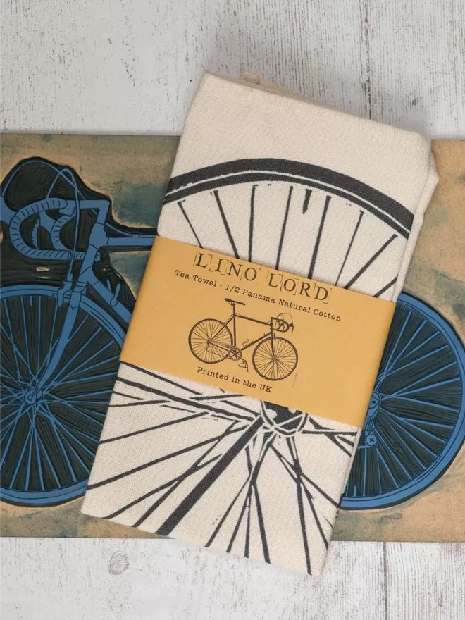 Picture of a tea towel with an image of a Bicycle, taken from an original lino print