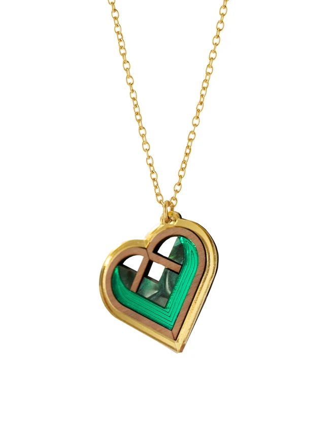 green and gold heart necklace on white background