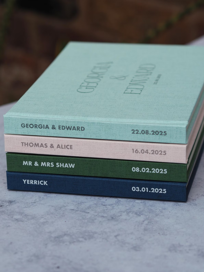 personalised wedding guestbook. personalised wedding guestbooks stacked on top of each other to show spines.