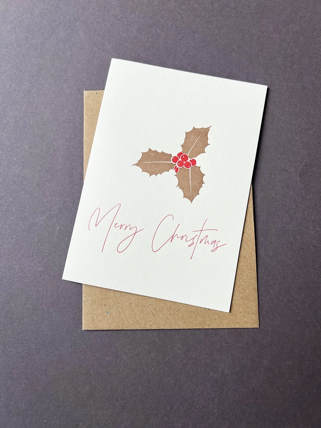 Metallic gold Holly with bright red berries and the words "Merry Christmas" underneath.