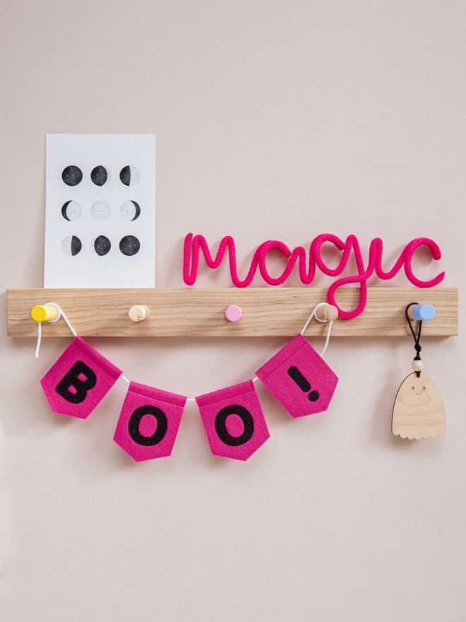 pink, felt spearhead halloween bunting with text that read "BOO!" in black glitter felt.