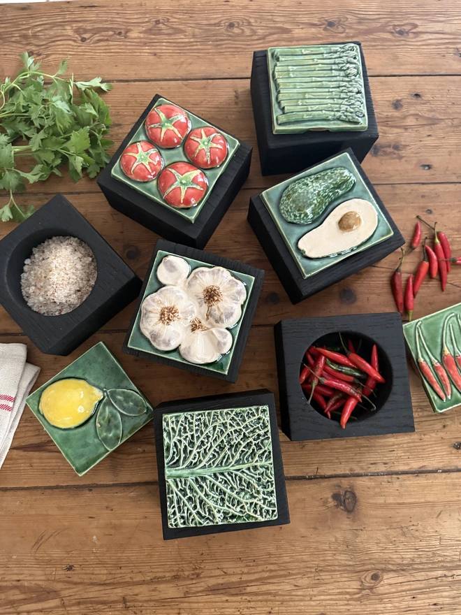Assorted ceramic  lid tops on yakisugi charred oak pots Tomatoes ,garlic.lemon.avocado,chilli peppers,asparagus and savoy cabbage 