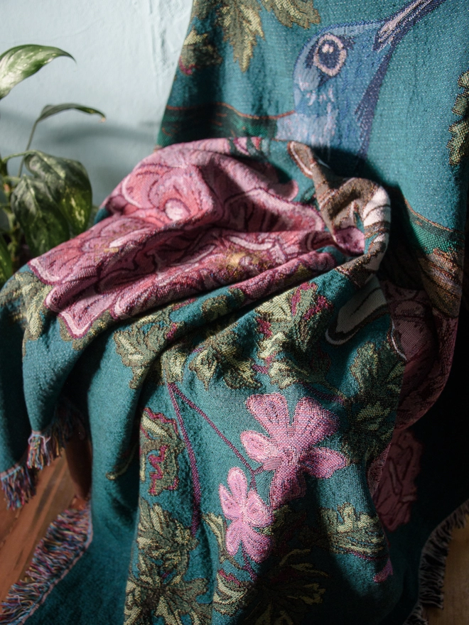 Joy Hummingbird Woven Blanket on chair