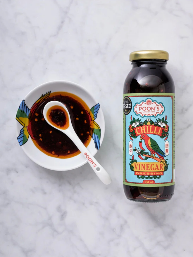 Chilli Vinegar Dressing. A bottle of sauce with a sample in a dish.