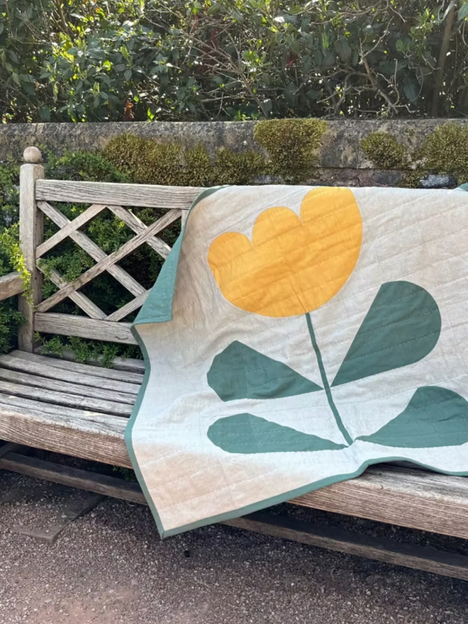 Grow & Bloom Yellow Quilt. A white, green and yellow quilt.