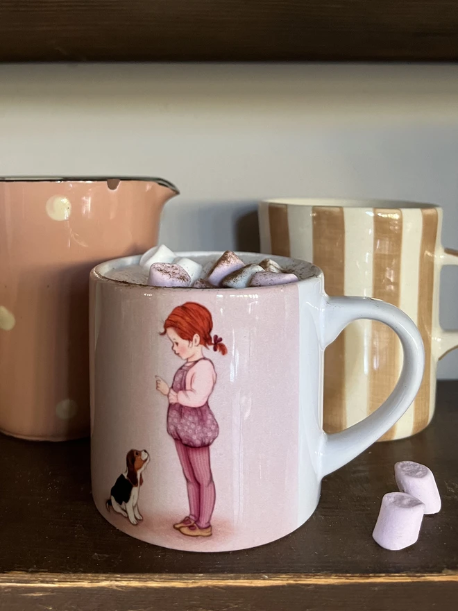 a small ceramic mug featuring a vintage style story book illustration of a little girl and her beagle dog pink and lilac
