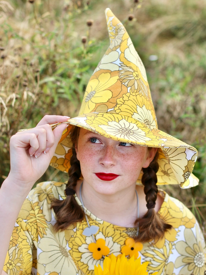 Handmade upcycled vintage fabric witch hat for Samhain worn by girl in field