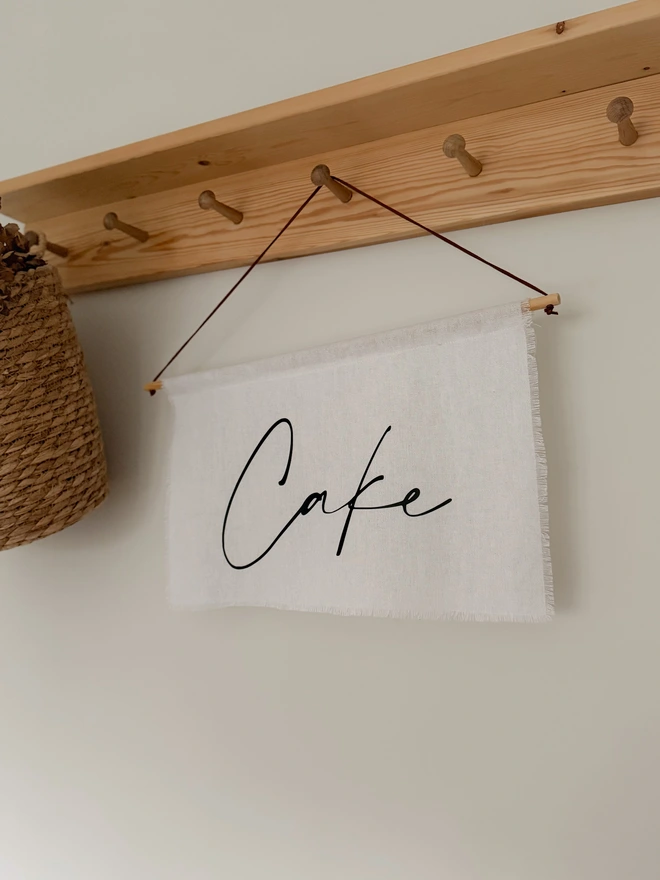 A linen hanging cake banner to display from wedding cake/dessert tables