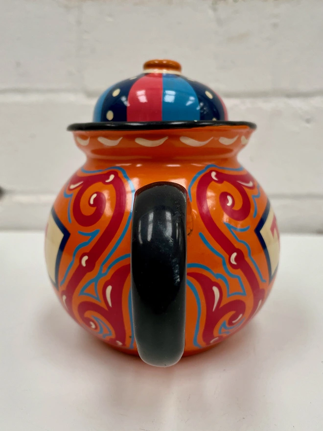 Small orange vintage teapot, hand painted with a design inspired by traditional scrollwork.