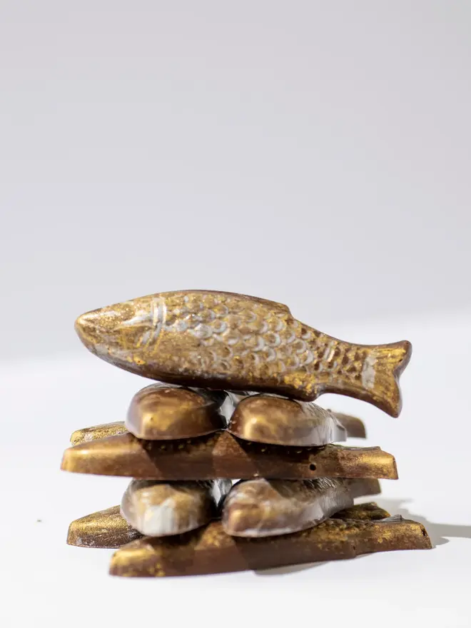 Chocolate fish stacked on a white table. 