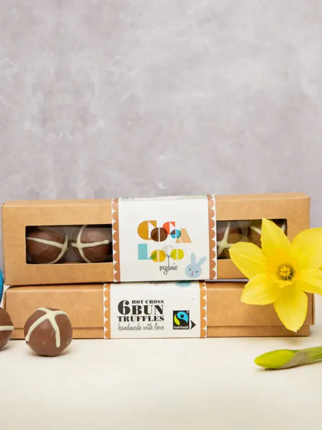 Chocolate easter truffles in a box next to some daffodills