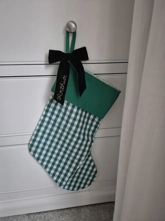 green gingham stocking with dark greeen velvet bow with emboridered name