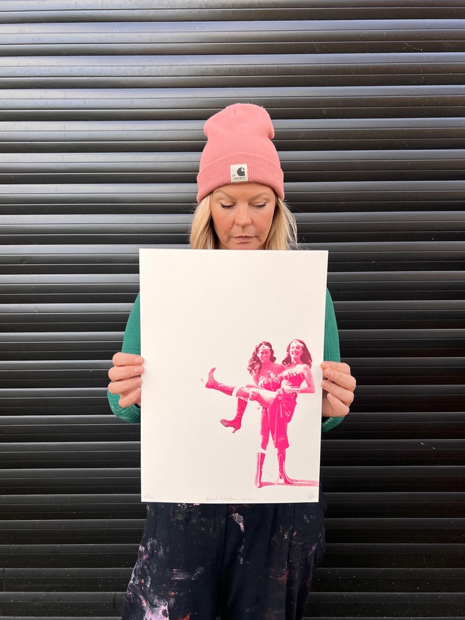 Woman artist holding original artwork screen print of Lynda carter and her stunt double, strong women, women supporting women 